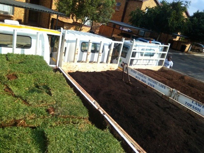 Hydro Gardens Instant Lawn delivery trailer with rolled lawn and topsoil